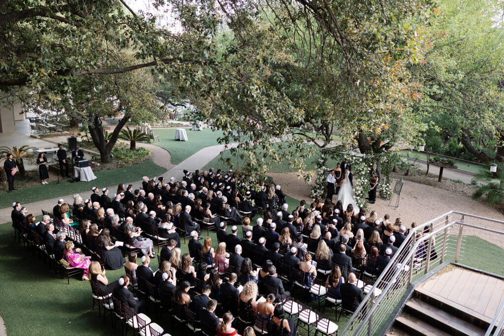 Outdoor wedding ceremony on the back lawn at Four Seasons Austin with Lady Bird Lake in the background