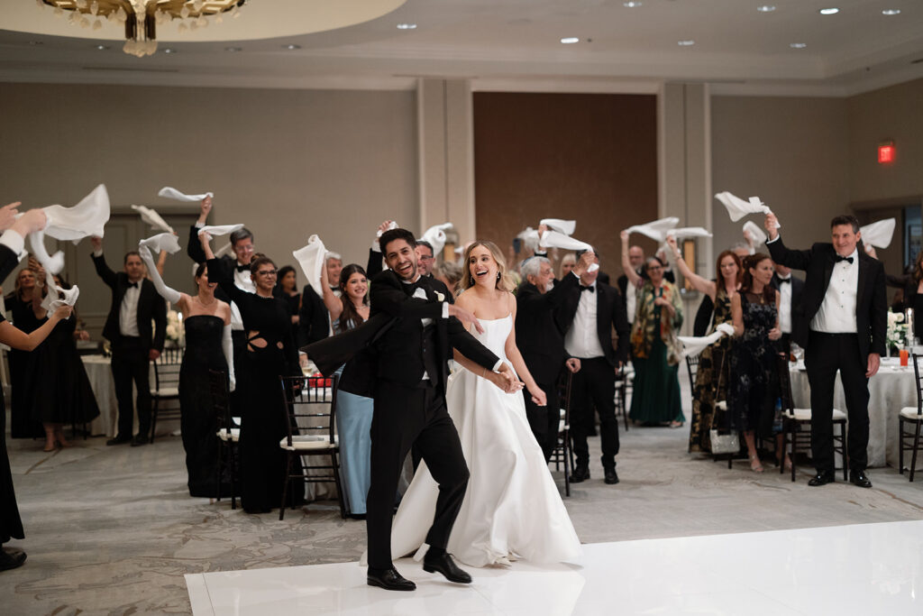 Wedding reception inside the Four Seasons Austin ballroom with soaring ceilings and elegant decor
