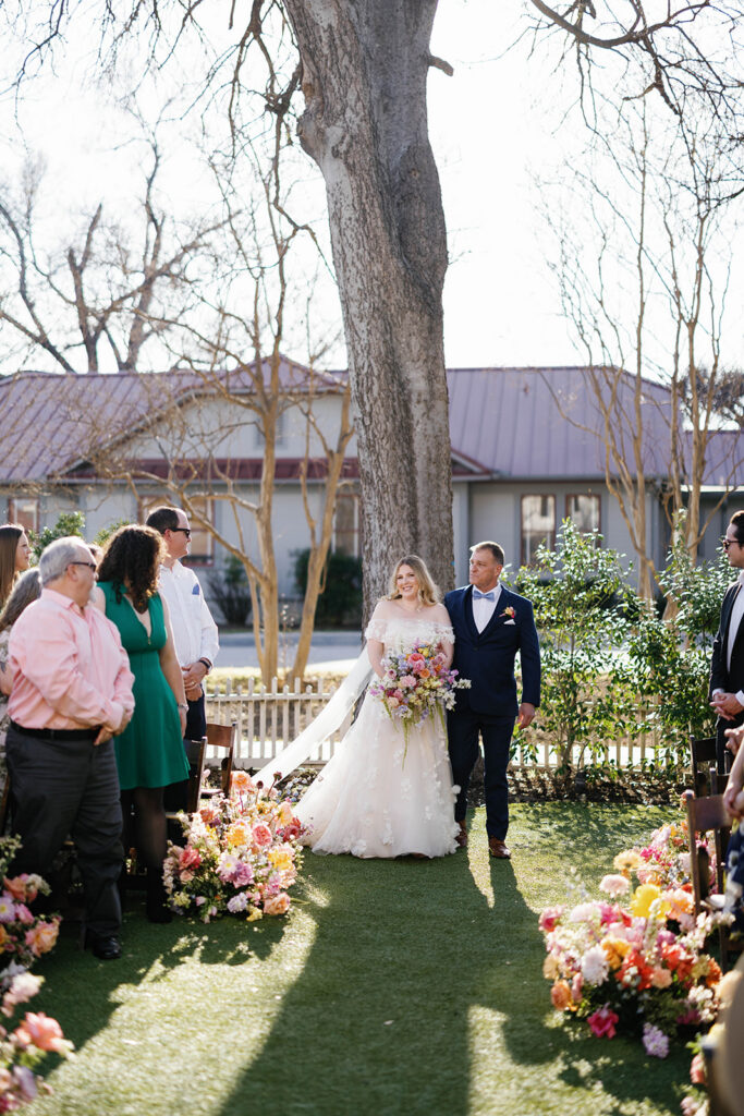 Outdoor wedding ceremony under oak trees at Woodbine Mansion in Round Rock Texas