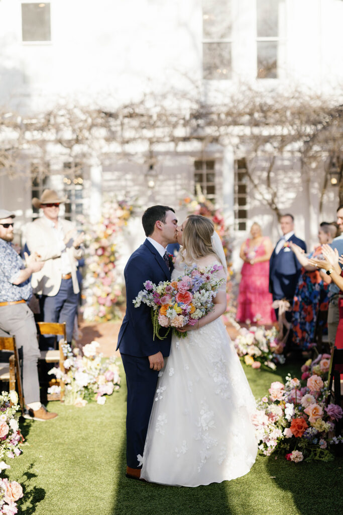 Outdoor wedding ceremony under oak trees at Woodbine Mansion in Round Rock Texas