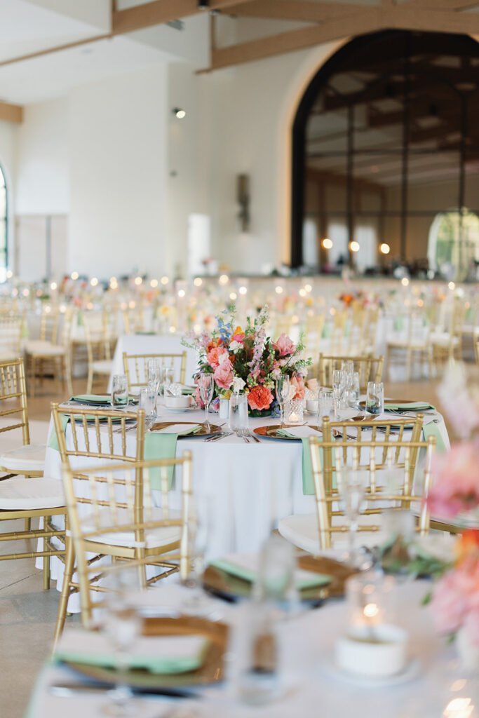 Wedding reception tablescape with gold chiavari chairs and sage green napkins at La Cantera Resort & Spa