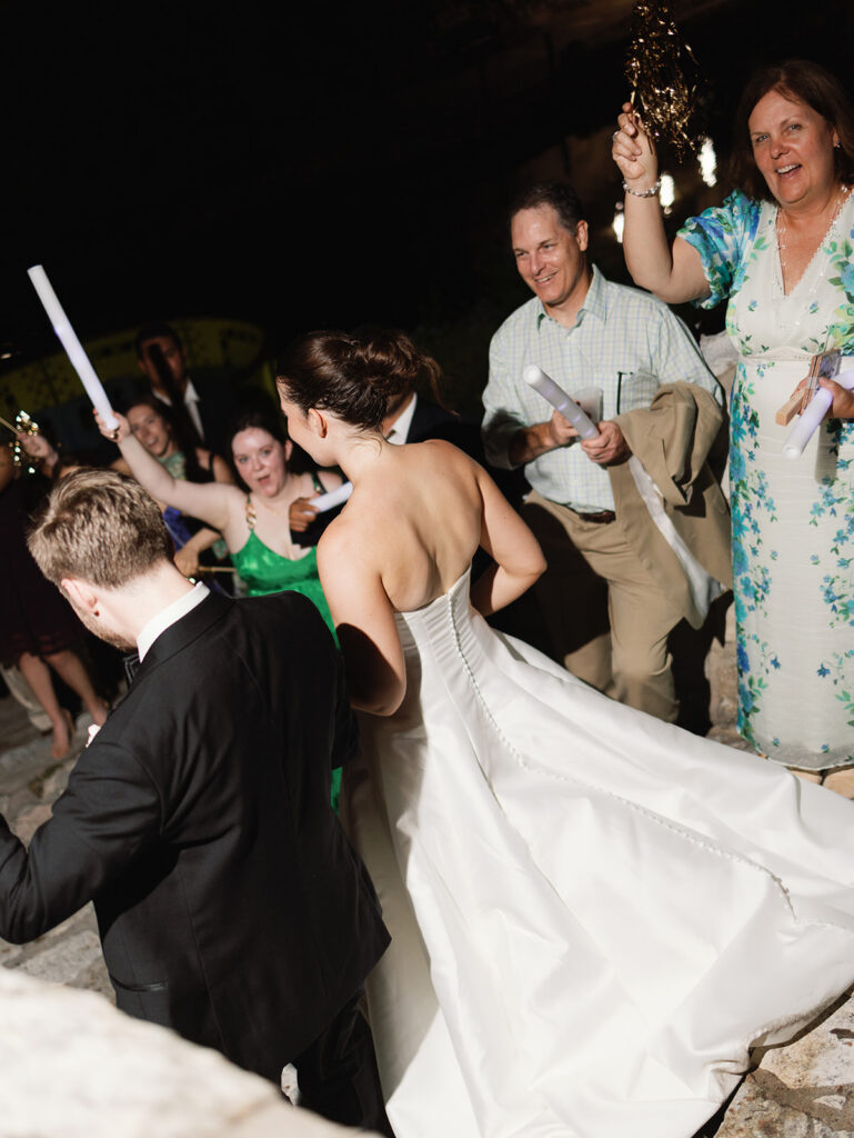 Guests cheering as newlyweds depart by riverboat in San Antonio